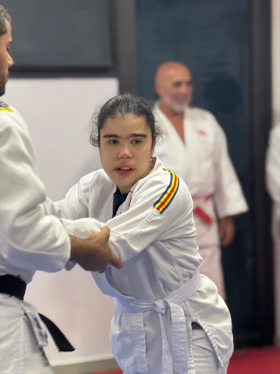 Judoca do projeto praticando movimento com acompanhamento próximo durante uma aula real